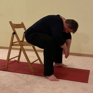 Kindshaltung Variante Stuhl Kurvige Frau mit Stuhl als Hilfsmittel für eine Variation der Kindshaltung