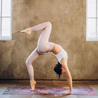 Schlanke Frau zeigt Yogahaltung Das Rad